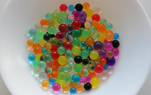 Colorful marbles in a wicker basket.