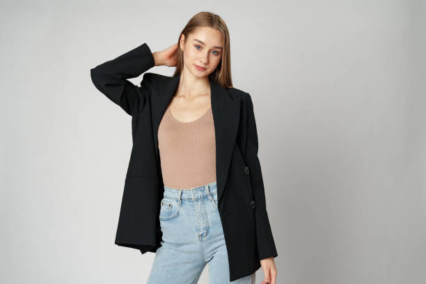 istock Young Woman Wearing Black Jacket and Jeans posing on gray background studio shot . 2148792434