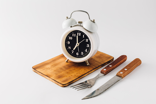 Alarm clock with wooden tray and knife , fork