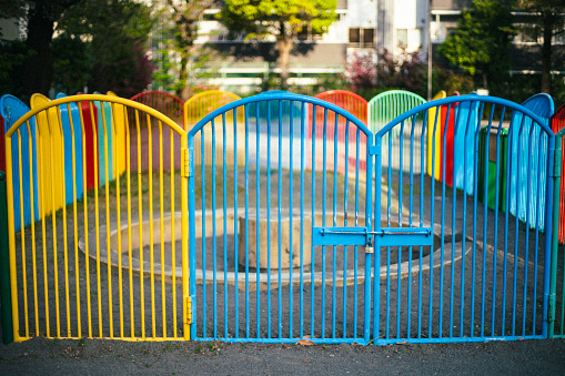 An iron fence surrounding a sandbox in a children's park.