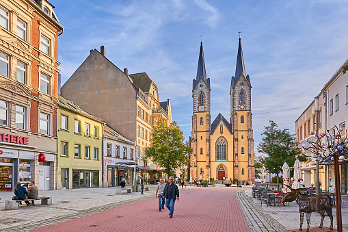 Hof, Germany - September 19, 2023: pedestrians in the old town of Hof. In the background is St. Mary's Church on Lorenzstrasse.
