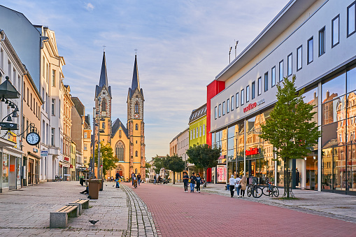 Hof, Germany - September 19, 2023: pedestrians in the old town of Hof. In the background is St. Mary's Church on Lorenzstrasse.