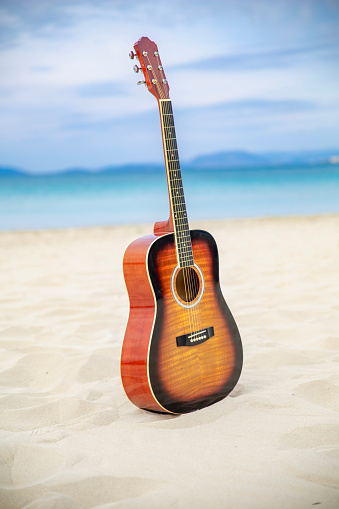 Closeup of an acoustic guitar on brown wood background.