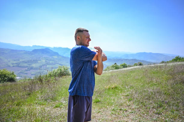 athlete stretching arm against clear sky