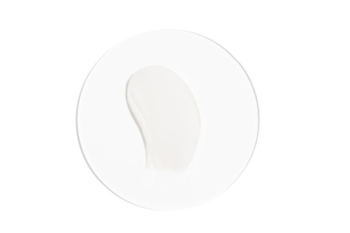 White cream sample on glass on white isolated background. A concert of beauty, moisturizing and nourishing products for the skin.