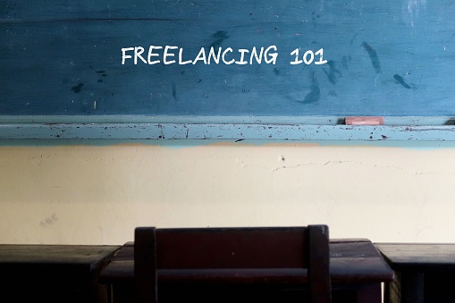 Chalkboard on with handwriting text FREELANCING 101, concept of what to learn before becoming a self-employed freelancer - understand the nature of freelance work