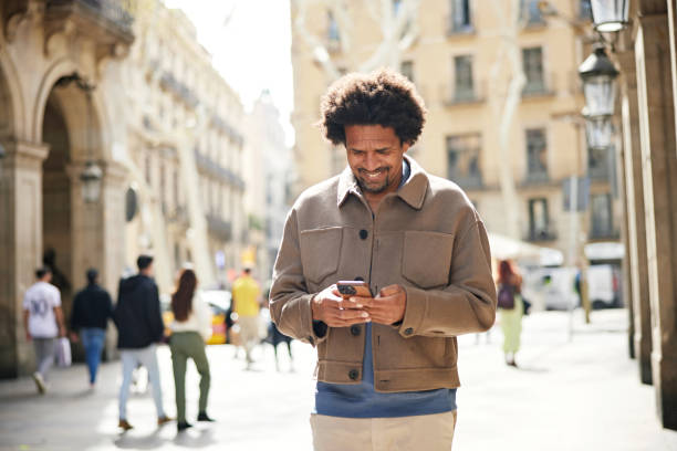 istock Smiling man communicating with friend on smart phone 2148802043