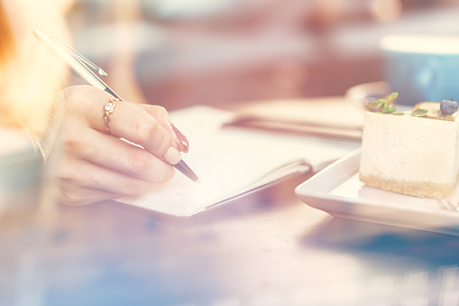 Woman making notes while sitting in a coffee shop