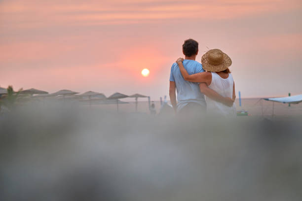 Senior couple enjoying sunrise on a beach vacation. Active seniors.