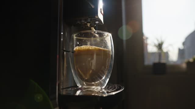 Coffee machine pouring milk in shot of coffee to prepare cappuccino