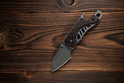 Tactical knife on a wooden background.
