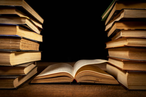 istock opened book, lying on the bookshelf in library 2148803609