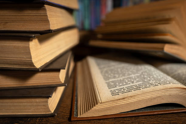 istock opened book, lying on the bookshelf in library 2148803627