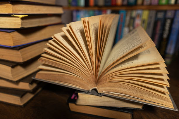 istock opened book, lying on the bookshelf in library 2148803693