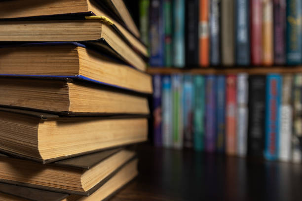 istock Book stack in the library room and blurred bookshelf for business and education background, back to school concept 2148803775