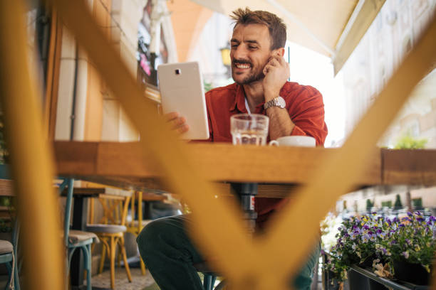 istock An adult man is sitting in a restaurant and using a digital tablet. 2148803929