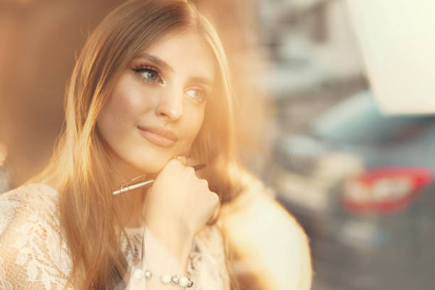 Portrait of young woman, teen girl with long blond hair outdoors