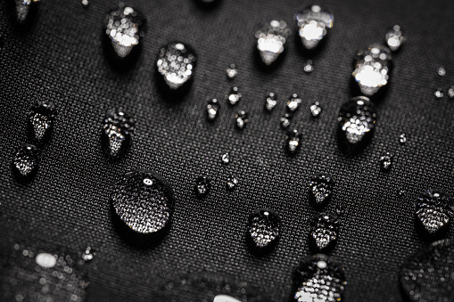 Water drops on waterproof black fabric