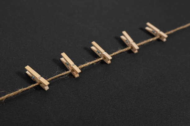istock wooden clothespins on rope on dark background 2148805380