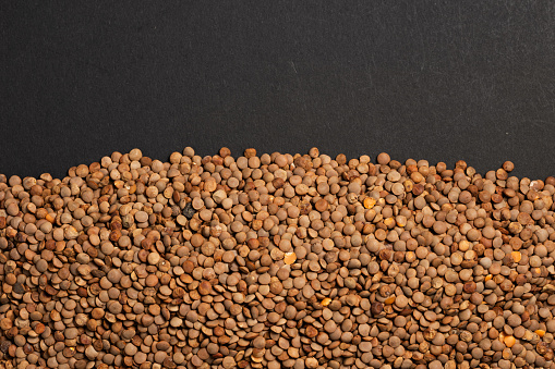 Brown lentils, The lentil Lens culinaris or Lens esculenta, an edible legume. It is an annual plant known for its lens-shaped seeds, the largest producer is Canada, pile of dark grains lentil