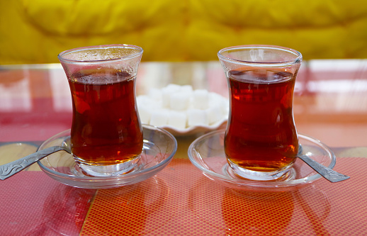 Closeup of a Pair of Hot Turkish Tea with Plate of Sugar Cubes in the Backdrop