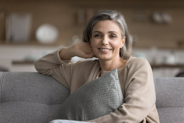 istock Woman enjoy weekend relaxation seated on comfortable couch at home 2148807636