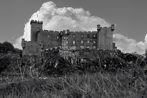 Dunvegan - United Kingdom. May 23, 2023: The historical Dunvegan Castle, captured in black and white, stands out against the Scottish landscape