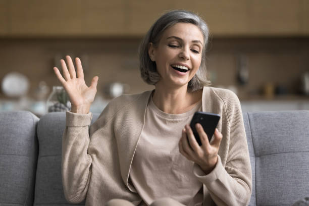 istock Happy older woman use cellphone for video call with friends 2148808475