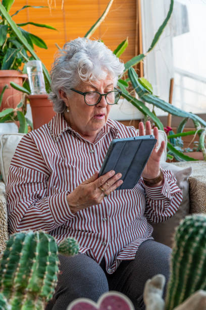 istock Confused elderly woman looking at device screen 2148808685