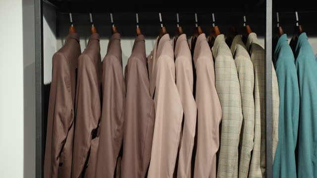 Luxury men's suits on hangers in a clothing store