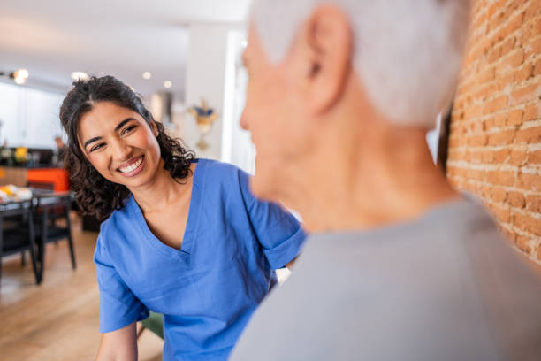 istock Physiotherapist helping senior man exercising at home 2148812263