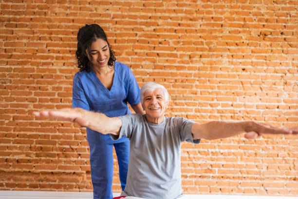istock Physiotherapist helping senior man exercising at house 2148812326