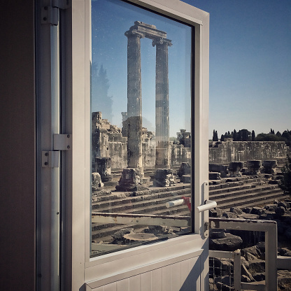 The front of the temple of Apollo seen through the glass window of the ticket office door. Didim Turkey