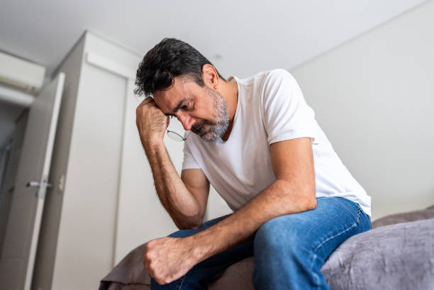 istock Worried mature man sitting on bed at home 2148812574
