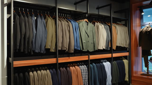 Luxury men's suits on hangers in a clothing store