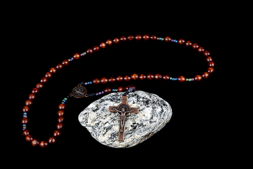 Small olive wood rosary on the open Bible, elements for prayer