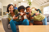 aufgeregte-mutter-und-kinder-sitzen-zu-hause-auf-dem-sofa-und-spielen-computerspiele.jpg?b=1&s=170x170&k=20&c=sTrqlp-TAx8z8zBZKXrnrw0-FeK9auNlLQkX4q-Qswg=