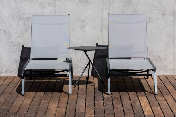 istock Two Modern Lounge Chairs and a Side Table on a Wooden Deck Under Sunlight 2148813798