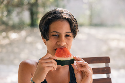 Teenage girl eating a slice of watermelon, healthy and natural food