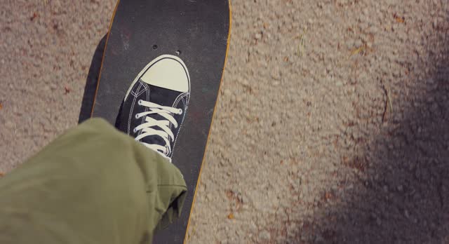 man riding a skateboard on city asphalt. street skateboarding. POV slow motion