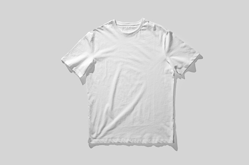 Plain White T-Shirt Laid Flat Against a Solid Gray Background