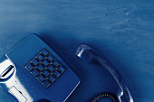 Retro telephone of blue color on classic blue background