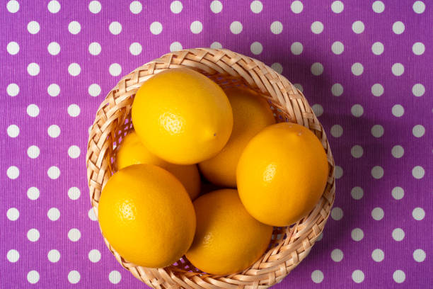 Basket of lemons on dotted purple tablecloth