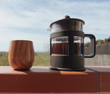 French press and wooden mug, outdoors