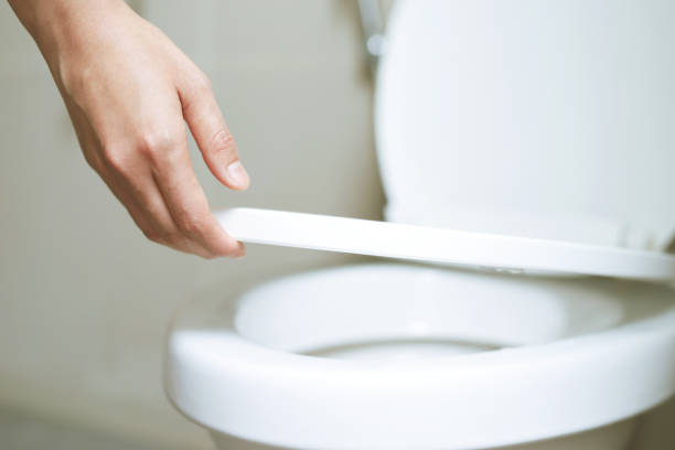 istock man's hand opening the toilet lid 2148818144