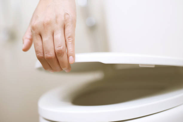 istock man's hand opening the toilet lid 2148818172