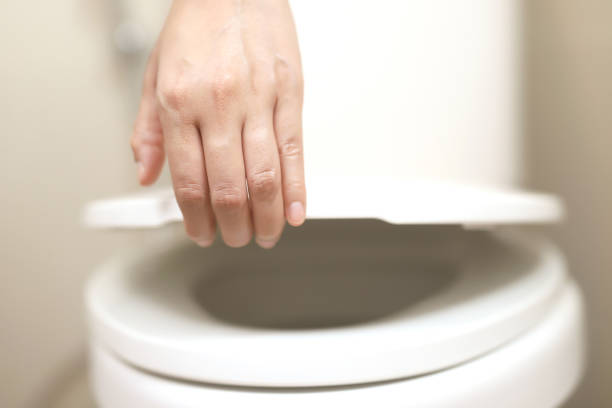 istock man's hand opening the toilet lid 2148818174
