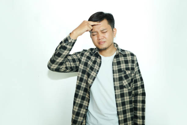 istock Young Asian man shows an expression of pain while touching the right side of his head 2148819854