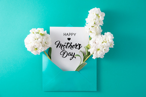 Flowers in turquoise colored envelope with Mother’s Day greeting card