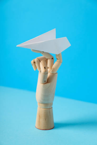 istock Wooden hand with paper plane on blue background 2148820339